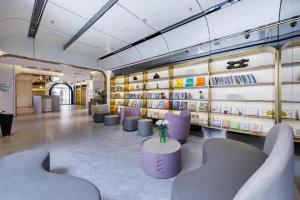 a library with purple chairs and shelves of books at Atour Light Hotel Zhuguang Road Hongqiao National Exhibition and Convention Center in Shanghai