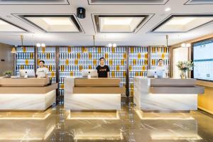 um lobby de um hotel com três pessoas sentadas em mesas em Atour Hotel Hangzhou Huanglong Wanke Xueyuan Road em Hangzhou