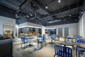 a dining room with blue chairs and tables at Atour Light Hotel Hangzhou West Lake Wulin Plaza North Huancheng Road in Hangzhou