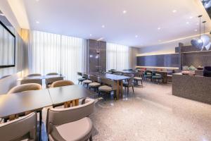 - un restaurant avec des tables et des chaises dans une salle dans l'établissement Atour X Hotel Beijing Majiabao Subway Station, à Pékin