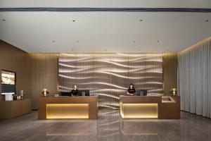 two people sitting at reception desks in a lobby at Atour Hotel Huizhou Huiyang New Metropolis in Huizhou