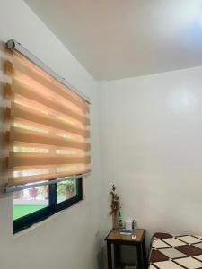ein Schlafzimmer mit einem Fenster mit einer Holzblende in der Unterkunft Queen's Room Rental 4 in El Nido