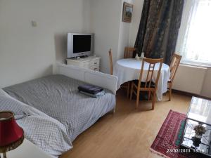 Schlafzimmer mit einem Bett und einem Tisch mit einem TV in der Unterkunft Room in Guest room - Chambre C A Bruxelles in Brüssel