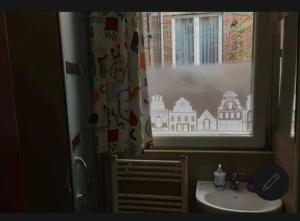 een badkamer met een wastafel en een raam met een gebouw erop getekend bij Room in Guest room - Chambre C A Bruxelles in Brussel