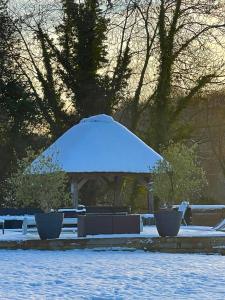 a gazebo with snow on top of it at LES 2 CHAUMIÈRES Piscine & Spa in Ablon