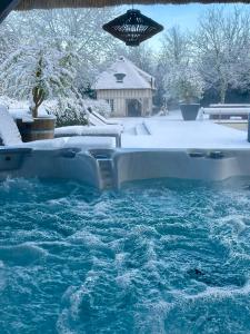 a swimming pool with snow on the ground at LES 2 CHAUMIÈRES Piscine & Spa in Ablon