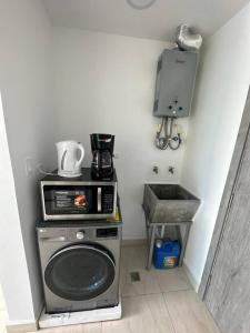 a kitchen with a microwave and a washing machine at Amazing Ocean View 1bed Suite in Panama City