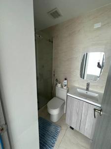 a bathroom with a toilet and a sink and a mirror at Amazing Ocean View 1bed Suite in Panama City