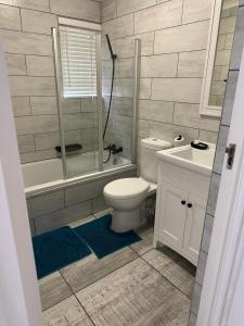 a bathroom with a toilet and a tub and a sink at Villa del Sol Margate in Margate