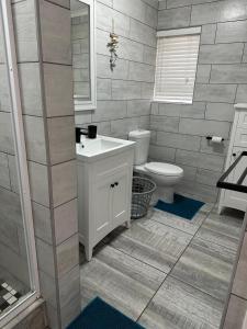 a bathroom with a white sink and a toilet at Villa del Sol Margate in Margate