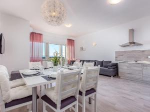 a dining room and living room with a table and chairs at Gorgeous homes with swimming pool jacuzzi and a magnificent sea view in Dramalj