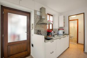 uma cozinha com armários brancos e uma porta de madeira em Lami Apartment Intra Center - Happy Rentals em Verbania