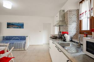 uma cozinha com um lavatório e uma cozinha com uma cama em Lami Apartment Intra Center - Happy Rentals em Verbania