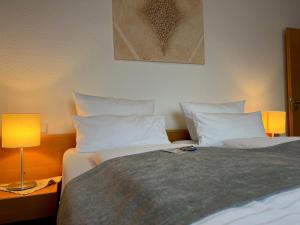 a bedroom with two beds with white pillows at Hotel Restaurant Kreuz Spaichingen in Spaichingen