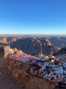a bed sitting on the edge of a mountain at Saint Catherine Peak Camp Sunrise Adventure & Church in Saint Catherine