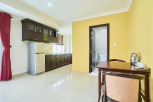 a kitchen with a table and a kitchen with yellow walls at Bonita Boutique Hotel in Ho Chi Minh City