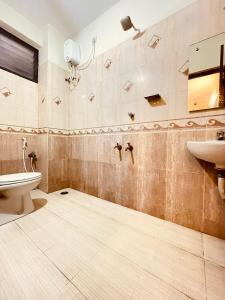 a bathroom with a toilet and a sink at HALF MOON INN in Chennai