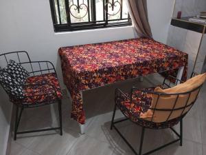 恩德培的住宿－Mini Lookout Entebbe，桌子和两把椅子以及一张桌子和一把椅子