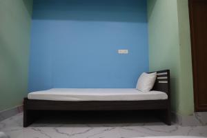 a bed in a room with a blue light at Hotel Saan in Baharampur