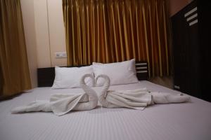 two swans made out of towels on a bed at Hotel Saan in Baharampur