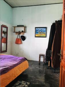 a bedroom with a bed and a mirror and a chair at RosiesHome in Da Lat