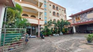 a woman is standing in front of a building at Hotel Silicon Residency Puri Excellent Service Awarded - Parking & Lift facilities in Puri