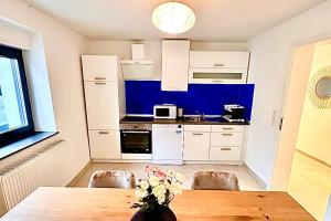 a kitchen with a wooden table with a vase of flowers at Beautiful House in Salzweg in Salzweg