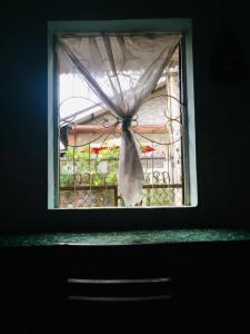 a window with a curtain on a fence in a room at RosiesHome in Da Lat