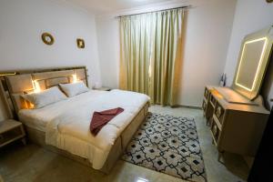 1 dormitorio con 1 cama grande y TV en نسائم صلاله NassayemSalalah en Salalah