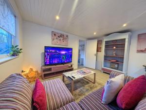 a living room with a couch and a tv at The Cabin in Bonnybridge