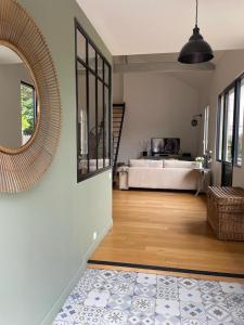 uma sala de estar com um espelho grande e uma cama em Charmante Echoppe en pierre proche gare em Libourne