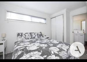 a bedroom with a bed with a floral bedspread at Modern cottage central location in Phillip