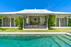eine Villa mit einem Swimmingpool vor einem Haus in der Unterkunft Vicolo ArtVillas in Uluwatu