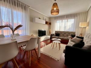 ein Wohnzimmer mit einem Tisch und einem Esszimmer in der Unterkunft Apartamento Dama Suances in Suances