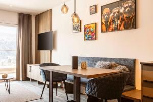 a living room with a dining room table and chairs at Brixental Suites Hopfgarten by ALPS RESORTS in Hopfgarten im Brixental +78 photos