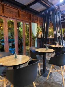 un restaurante con 2 mesas, sillas y ventanas en Park & Pool Resort, en Nong Khai