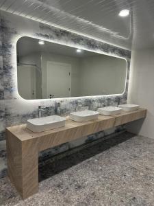 a bathroom with two sinks and a large mirror at Alvina apartment hotel in Tsaghkadzor