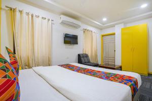 um quarto com uma cama grande e um armário amarelo em FabExpress Luxury Inn em Hyderabad