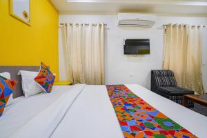 um quarto de hotel com uma cama e uma cadeira em FabExpress Luxury Inn em Hyderabad