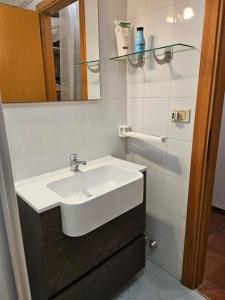 ein Badezimmer mit einem weißen Waschbecken und einem Spiegel in der Unterkunft Dimora Fiore in Lucca