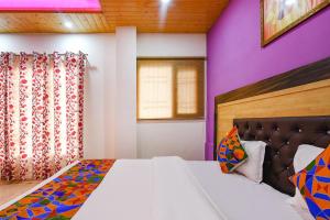 a bedroom with a large bed and a purple wall at FabHotel The Kasauli Heavens in Kasauli