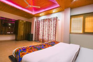 a bedroom with a bed and a pink ceiling at FabHotel The Kasauli Heavens in Kasauli