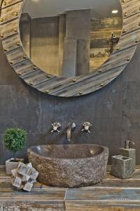 a bathroom with a stone sink and a large mirror at Lux View Villas in Kyra Panagia