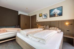 twee bedden in een hotelkamer met twee bij Brixental Suites Hopfgarten by ALPS RESORTS in Hopfgarten im Brixental