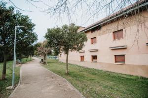 a building with a sidewalk next to a building at Poloestudios in Zaratán