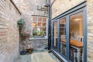 a brick building with a window and a wooden table at Bright De Beauvoir Pied à Terre in London