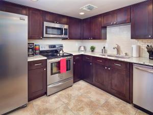 a kitchen with wooden cabinets and stainless steel appliances at Scottsdale Vacation Rentals in Scottsdale