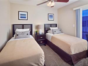 sypialnia z 2 łóżkami i wentylatorem sufitowym w obiekcie Scottsdale Vacation Rentals w mieście Scottsdale