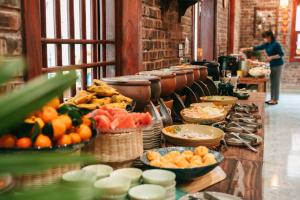 uma linha de buffet com frutas e legumes em tigelas em Trang An Heritage Garden em Ninh Binh