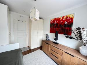 1 dormitorio con 1 cama y una pintura en la pared en Room in Stabekk Appartment en Stabekk